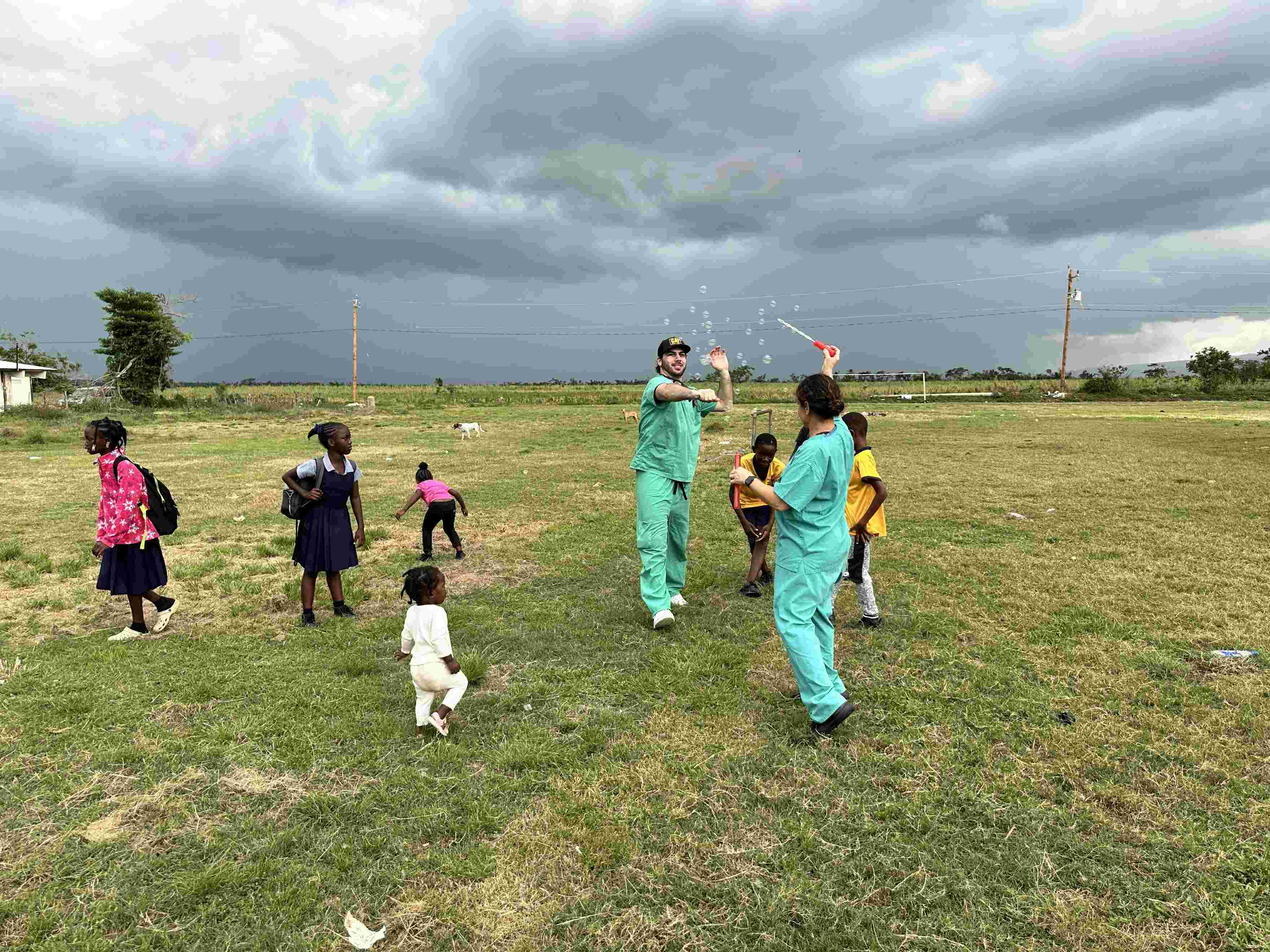 Kelvin and Jess playing with the kids out in the field